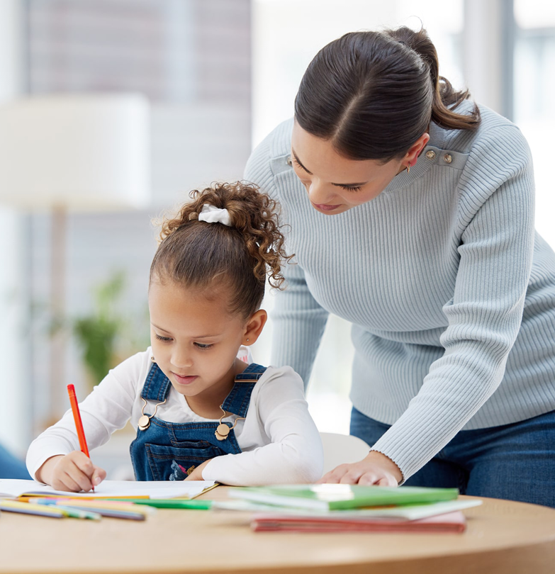ABA therapist guiding a young child in a drawing activity