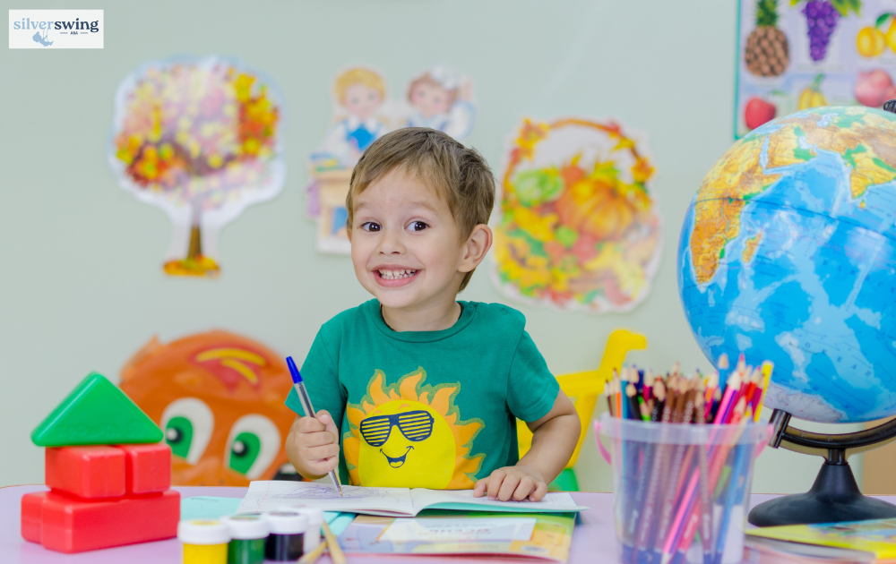 Smiling child drawing at a colorful desk