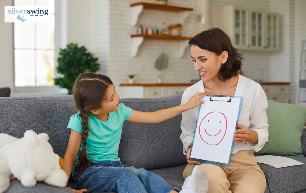 ABA therapist showing a smiley face to a girl