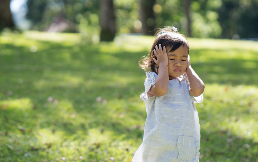 is putting hands over ears a sign of autism